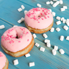 Photo of pink donuts on a blue background. Frame for text with donuts and sweets. Basis for a banner with donuts. Banner with donuts for social networks, shops, cafes