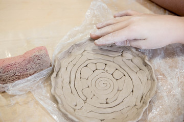 Children hands that mold from clay. Children creativity. Crafts from clay. Clay modeling courses