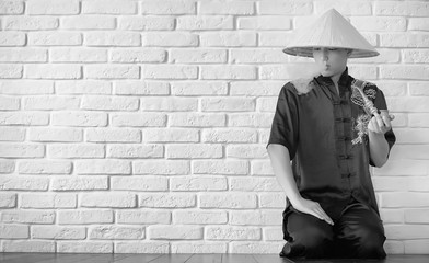 Asian novice on a white brick wall