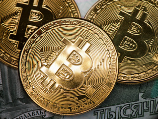 Golden bitcoins against 1000 rubles banknote background. Cryptocurrency