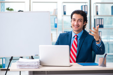 Young handsome businessman in front of whiteboard 