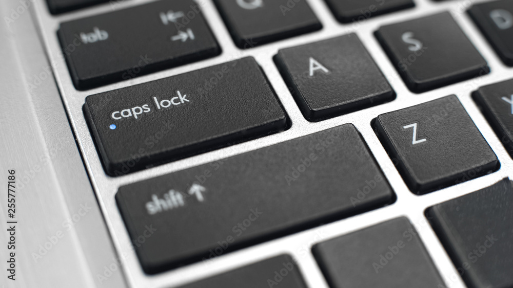 Fototapete switched on caps lock button on keyboard, typing capital letters, toggle key