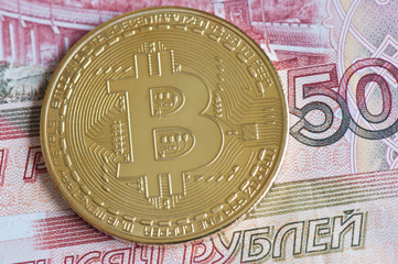 Golden bitcoin against 5000 rubles banknote background. Cryptocurrency