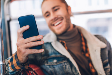 Close up joyful hipster male messaging in phone