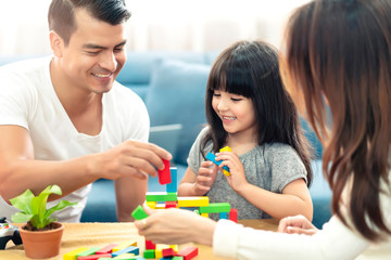 happy family caucasian and asian mixed race with pretty daughter enjoy family time with toy  together living room home background