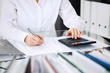 Unknown bookkeeper woman or financial inspector  making report, calculating or checking balance, close-up. Business portrait. Audit or tax concepts