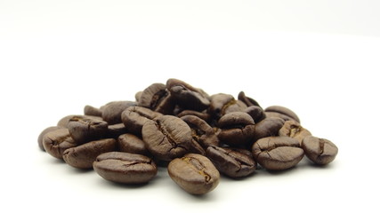Close up of roasted coffee beans on white background