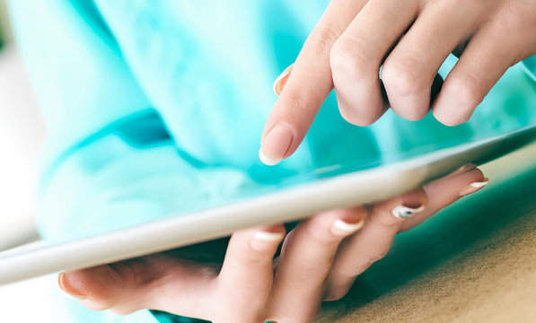 Close-up of female hands working with tablet computer. Woman using social network, texting and blogging. - Powered by Adobe