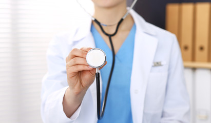 Unknown doctor woman holds stethoscope head, close-up. Physician ready to examine and help patient. Helping and insurance in health care, best treatment and medicine concept