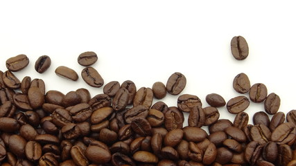 Naklejka premium Close up of roasted coffee beans on white background