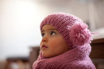 Cute little baby girl wearing purple woolen cap and warm scarf