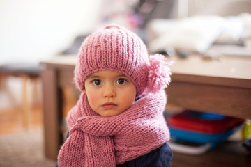 Cute little baby girl wearing purple woolen cap and warm scarf