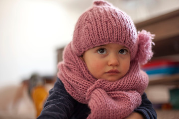 Cute little baby girl wearing purple woolen cap and warm scarf