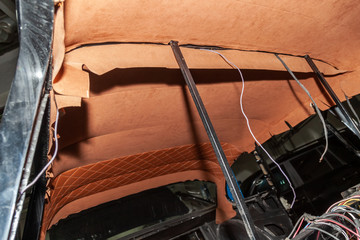 The ceiling of the SUV car pulled by bbrown and orange soft material in the workshop for tuning and styling the interior