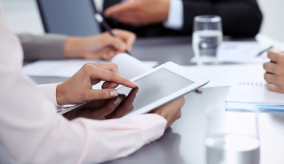 Woman hands using tablet at meeting. Business people group working together in office, close-up. Negotiation and communication concept