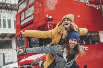 Happy beloved couple pretending to fly on street