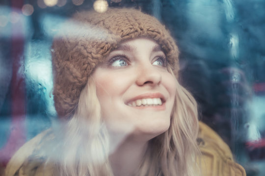 Happy hipster woman looking up from bus window