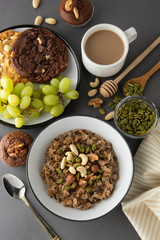 Healthy breakfast bowl. Oatmeal with nuts - walnuts, chia seeds, pumpkin seeds, honey and fresh fruits, isolated.