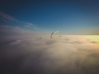 thick fog over the city in the rays of the rising sun