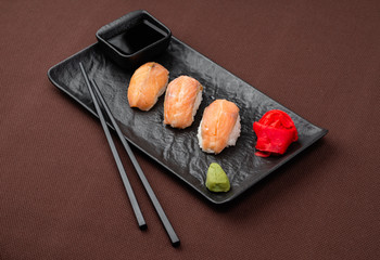 sushi with salmon on a black plate