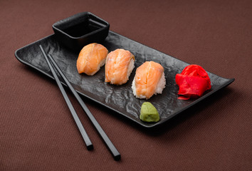 sushi with salmon on a black plate