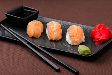 sushi with salmon on a black plate