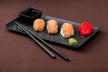 sushi with salmon on a black plate
