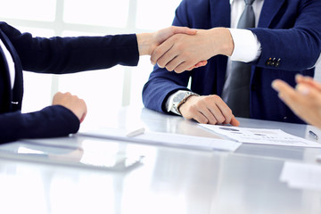 Group of business people or lawyers shaking hands finishing up a meeting , close-up. Success at negotiation and handshake concepts
