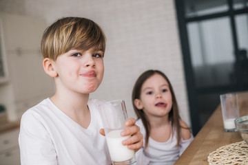 Low angle of happy children licking their mouthes at home