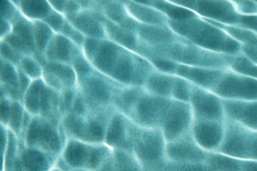 Reflective caustics on swimming pool floor from above water surface