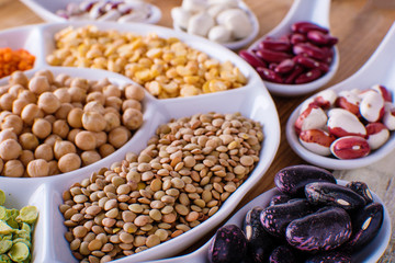Legumes, lentils, chikpea and beans assortment in different bowls.
