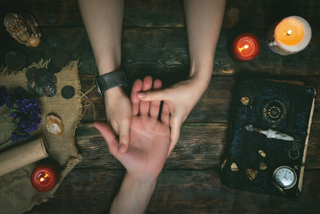 Palmistry concept. Fortune teller reading future on the hand on a magic table background. Future...
