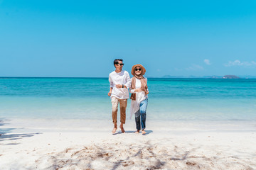 Young happy muslim couple white dress on running seashore. Travel Vacation Retirement Lifestyle Concept. young couple running together on the beach in vacation day. summer time.