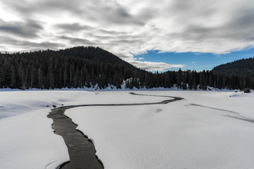 River in the bottom of the frozen lake in Rhodope mountain, Bulgaria