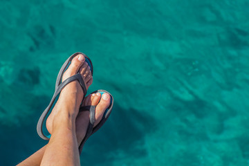 relaxation summer vacation concept simple wallpaper pattern with bare female feet in flip flops on...
