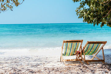 lazy chair on the sea beach and bright blue sky on a board day light with light yellow fine sand on sweet holiday.