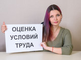 Office employee with a sign "Assessment of working conditions" at the table