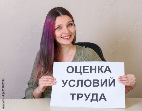 Office employee with a sign "Assessment of working conditions" at the table