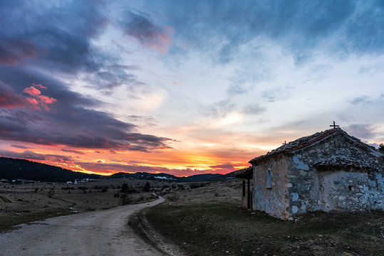 Dramatic colorful sunset in Rhodope mountain, near Dobrostan village. Small chapel "seint Ilia" in front. Bulgaria