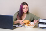 Young girl at the table in the office takes a croissant from a plate with pastries