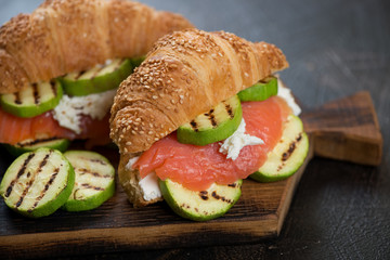 Croissants with trout fillet, grilled zucchini slices and ricotta cheese, close-up, selective focus
