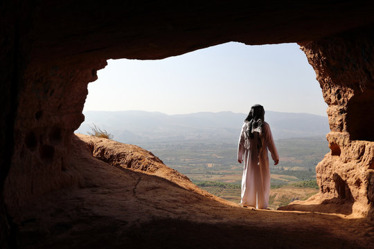 ARABIC MAN LOOKING A VALLEY FROM A CAVE