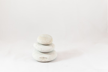 Fototapeta na wymiar Three smooth pebbles stacked with white background