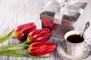 Fototapeta na wymiar Three red tulips on a light background.