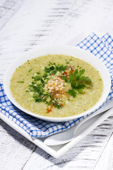 cold green gazpacho in a bowl, vertical