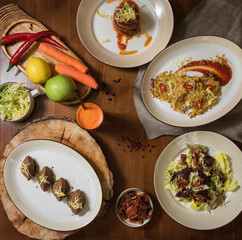 Healthy vegeterian food on brown wood board. Spring vitamin dieting food. Salad from beet with dried tomatoes and cabbage, potato vegan pancakes, dried tomatoes, pate from red beans, baked vegetables