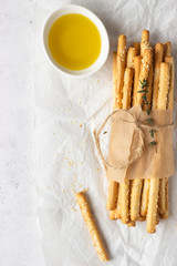 Italian grissini or salted bread sticks on a light stone background. Fresh italian snack. Copy space. 