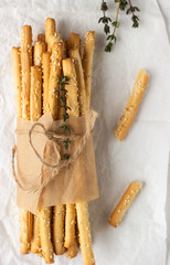 Italian grissini or salted bread sticks on a light stone background. Fresh italian snack. Copy space. 