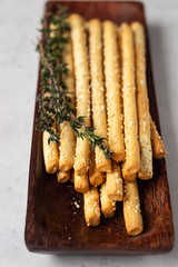 Italian grissini or salted bread sticks on a light stone background. Fresh italian snack. Copy space. 