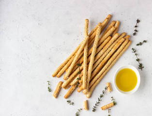 Italian grissini or salted bread sticks on a light stone background. Fresh italian snack. Copy...